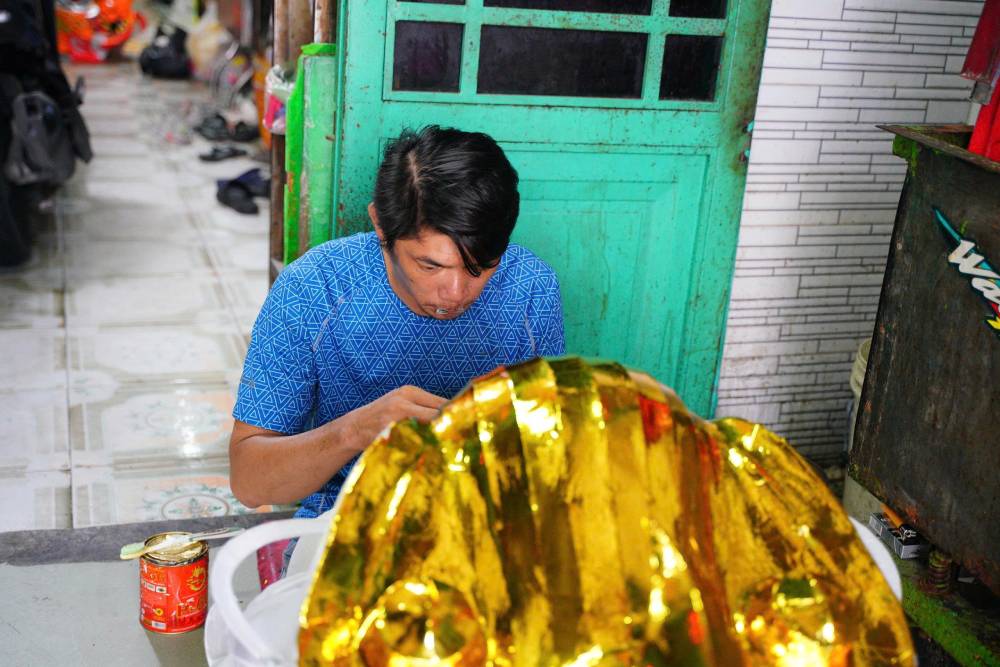 Người thợ tỉ mỉ vẽ từng họa tiết, “thổi hồn” cho chiếc đầu lân. Ảnh: Thái Bảo