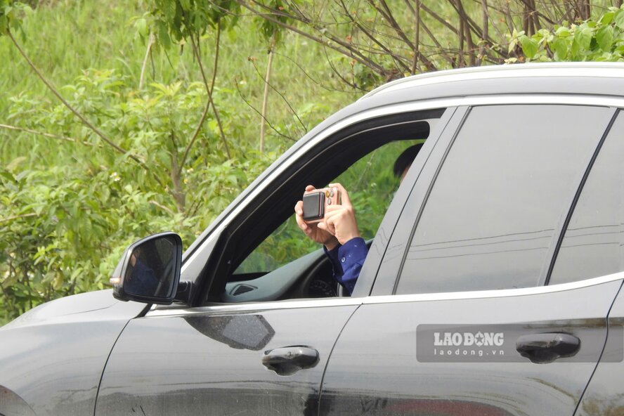 Người đi đường cũng tranh thủ dừng xe chụp ảnh hàng cây phong linh đang nở rộ. Ảnh: Tô Công