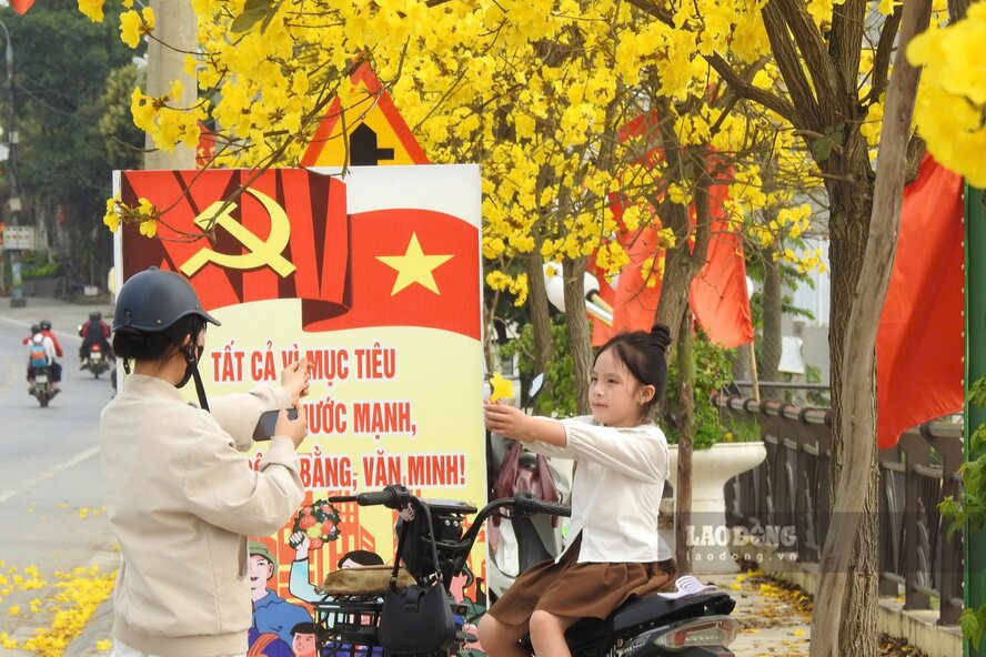 Các bạn trẻ thích thú chụp ảnh với hàng hoa phong linh. Ảnh: Tô Công