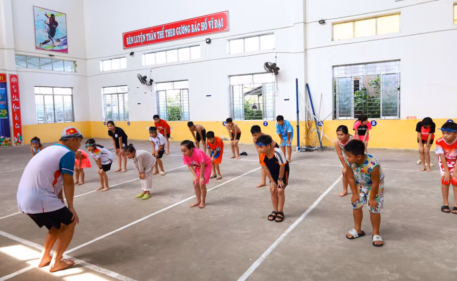 Thầy Đỗ Văn Thiệu hướng dẫn các em khởi động trước khi bơi. day-boi-mien-phi-4.jpg