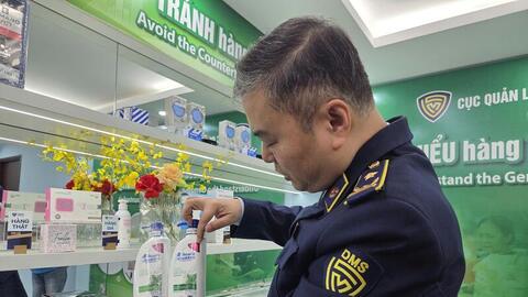 Cán bộ Quản lý thị trường hướng dẫn người dân cách nhận biết hàng giả