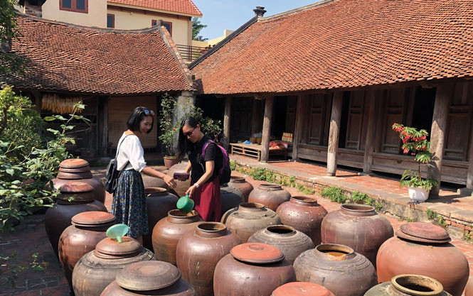 Du khách tham quan tìm hiểu về các sản phẩm truyền thống tại làng cổ Đường Lâm, thị xã Sơn Tây. Ảnh: VGP/TN