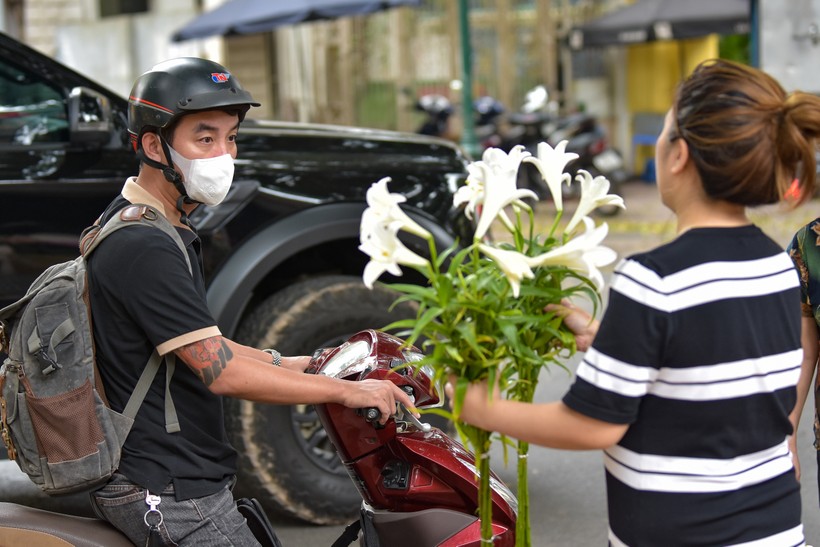 Đâu đâu trên những tuyến phố Hà Nội, dù có vội vã đến mấy cũng có người dừng lại bên những gánh hoa, chăm chú lựa chọn những nhành hoa ưng ý nhất đem về.