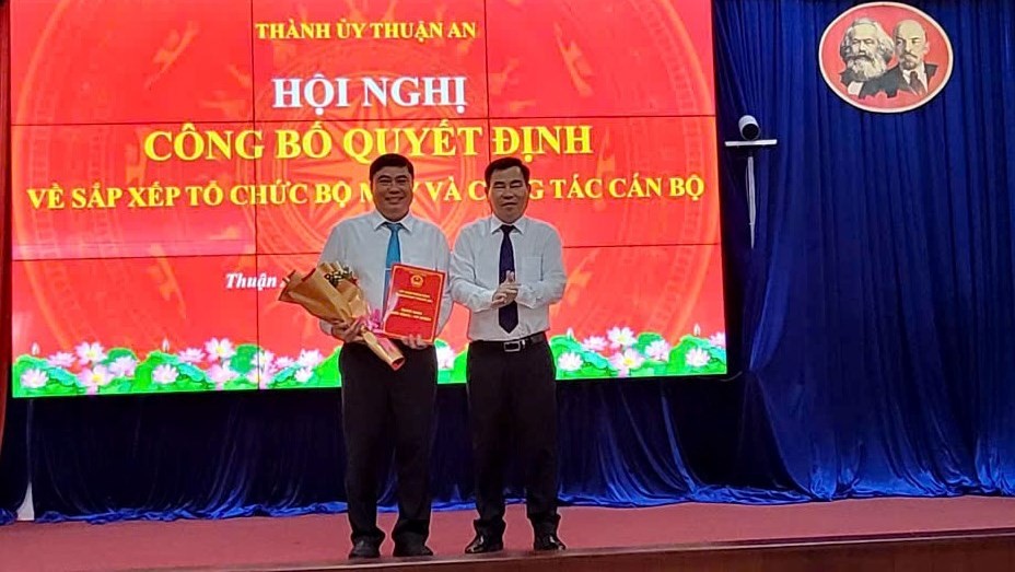 Ông Nguyễn Văn Minh, Bí thư Thành ủy trao quyết định bổ nhiệm Trưởng phòng Phòng Kinh tế, Hạ tầng và Đô thị thành phố cho ông Đàm Văn Ngôn (Ảnh: Thu Thảo)