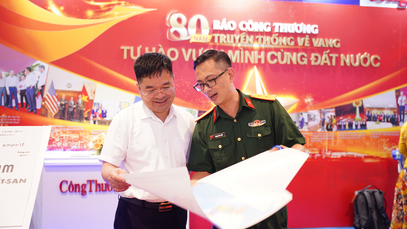 Tổng Biên tập Báo Công Thương trao đổi cùng khách tham quan về các ấn phẩm tại gian trưng bày
