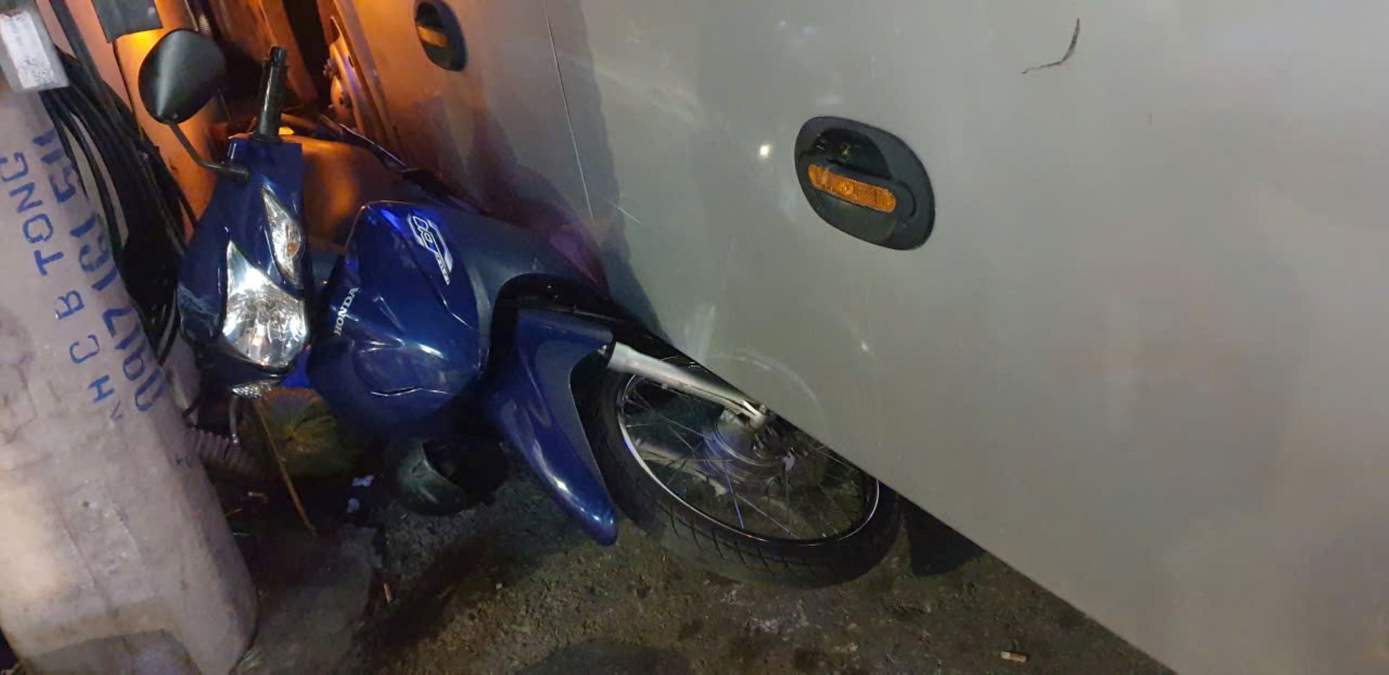 Một người lái xe ôm chạy thoát nhưng chiếc xe máy bị xe khách đè lên. Ảnh: Nguyễn Hùng