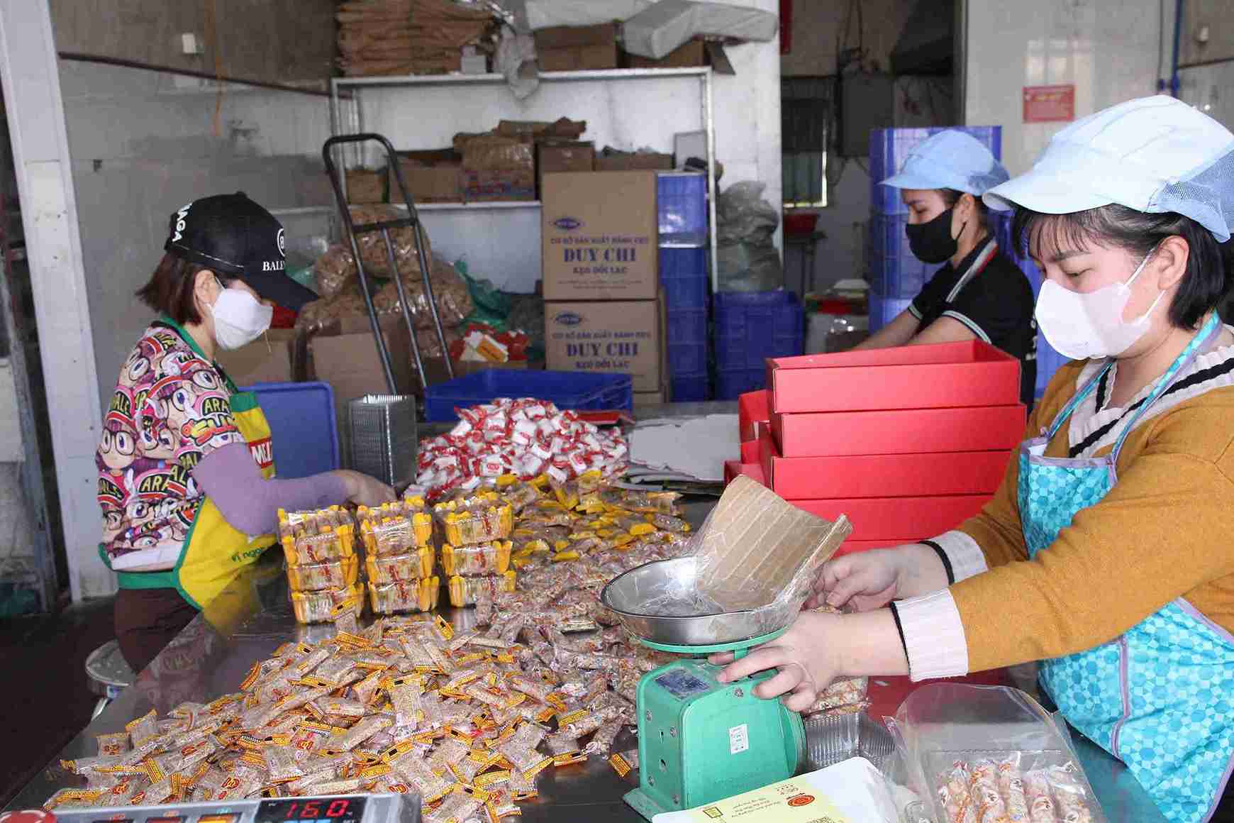Công nhân đang đóng bánh cáy tại cơ sở sản xuất. Ảnh: Mai Hương