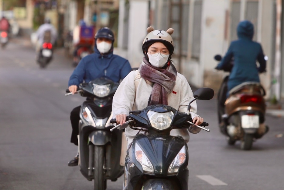 Nhiều người phải trang bị thêm khăn ấm để ngăn gió lạnh. Ảnh: Việt Anh.